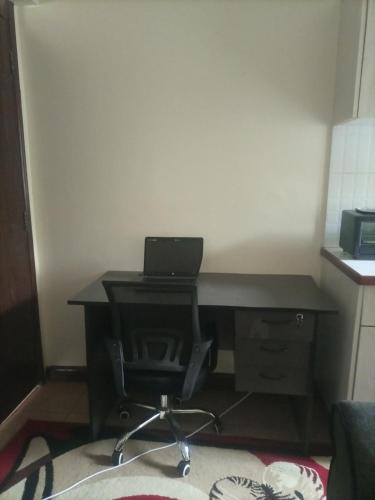 a desk with a laptop computer on top of it at Executive Suite Apartment in Nairobi