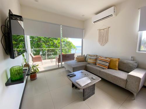 a living room with a couch and a table at BEACHFRONT APARTMENT Vistas de Bejuco in Parrita