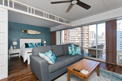 a living room with a couch and a bed at Semprose Ilikai Hotel in Honolulu