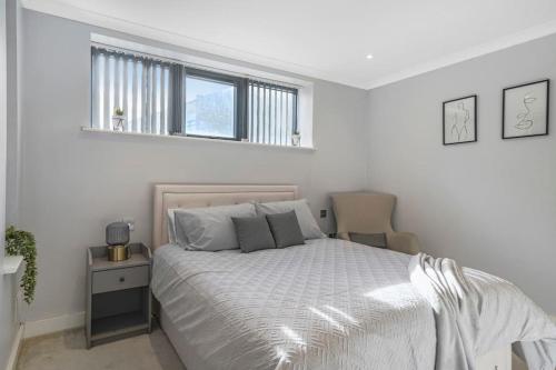 Habitación blanca con cama y ventana en Brentford's Oasis with Gated Parking, en Brentford