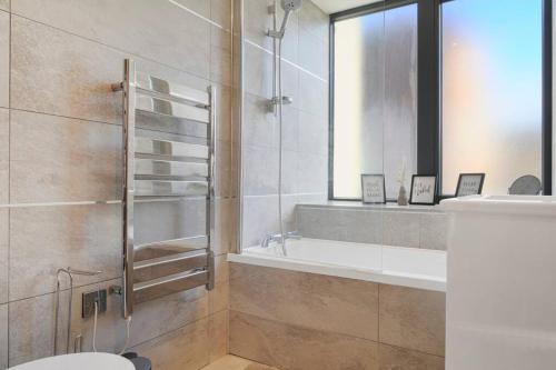 a bathroom with a shower and a toilet and a sink at Brentford's Oasis with Gated Parking in Brentford