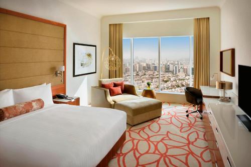 a hotel room with a bed and a large window at Marriott Hotel Downtown Abu Dhabi in Abu Dhabi