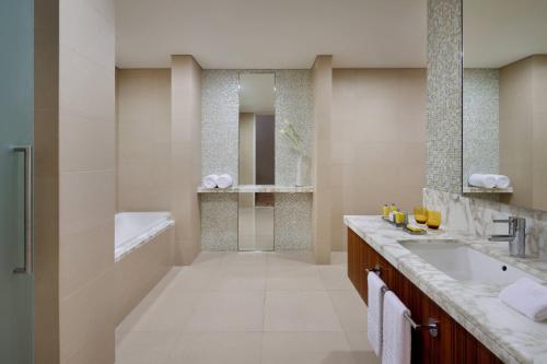 a bathroom with a tub and a sink and a shower at Marriott Hotel Downtown Abu Dhabi in Abu Dhabi