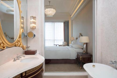 a bathroom with a bed and a sink and a mirror at Delta Hotels by Marriott Shanghai Baoshan in Baoshan