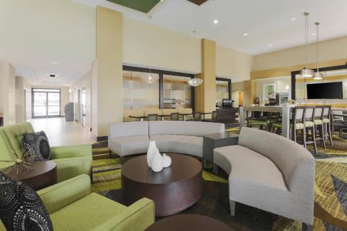 a living room with couches and a dining room at SpringHill Suites by Marriott Oklahoma City Quail Springs in Oklahoma City