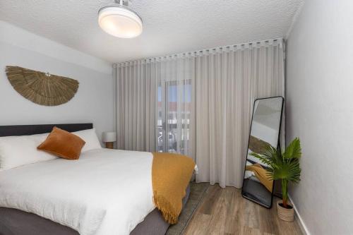sypialnia z białym łóżkiem i lustrem w obiekcie Totally Beachin' Two bed, prime holiday location walk to everything! w mieście Yamba