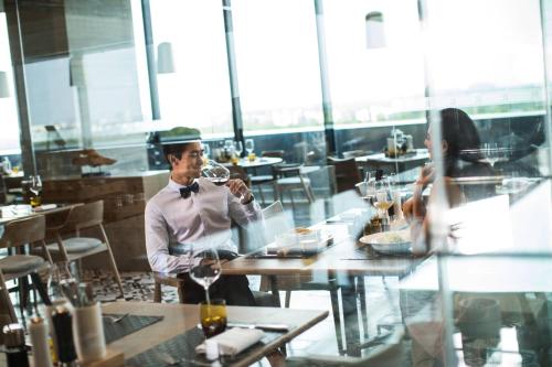 a man sitting at a table with a glass of wine at Renaissance Suzhou Wujiang Hotel in Suzhou