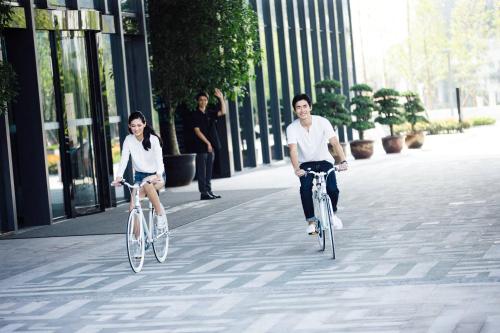 two people riding bikes down a city street at Renaissance Suzhou Wujiang Hotel in Suzhou