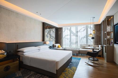 a bedroom with a bed and a living room at Renaissance Hangzhou Northeast in Yuhang