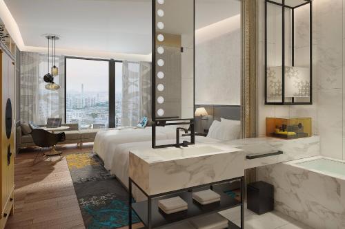 a bathroom with a bed and a tub and a sink at Renaissance Hangzhou Northeast in Yuhang
