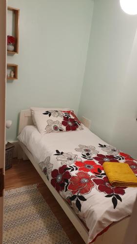 - une chambre avec un lit et une couette à fleurs dans l'établissement Private Room Guest Sleep, à Londres