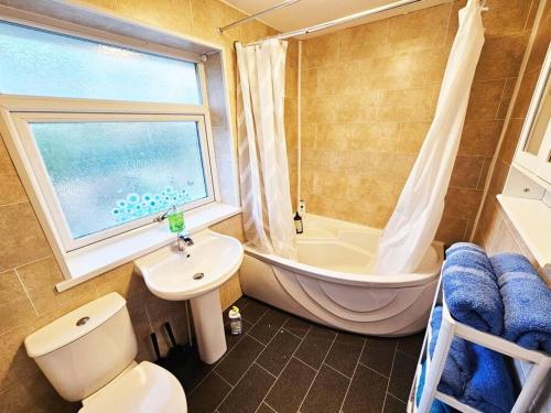 een badkamer met een bad, een toilet en een wastafel bij Moston, Manchester in Manchester