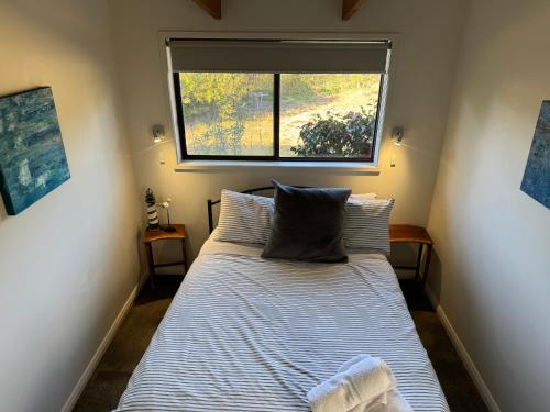 Dormitorio pequeño con cama y ventana en Beach front retreat at Dolphin Sands, en Dolphin Sands