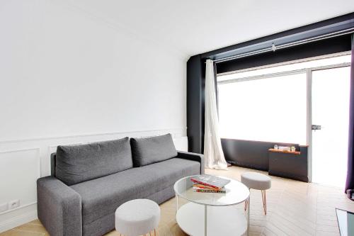 ein Wohnzimmer mit einem Sofa und einem Tisch in der Unterkunft Modern flexible apt- 1BR2P - Place de la Bastille in Paris