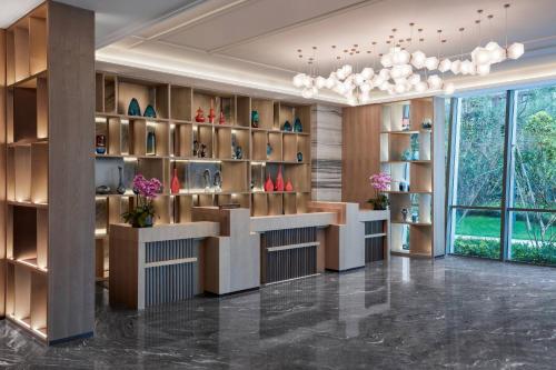 a lobby with a counter with vases on shelves at Delta Hotels by Marriott Kunming in Kunming