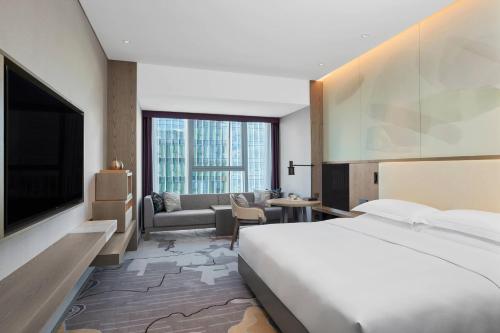 a hotel room with a bed and a living room at Delta Hotels by Marriott Kunming in Kunming