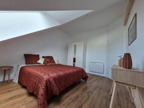 ein Schlafzimmer mit einem Bett mit einer roten Decke in der Unterkunft Appartement avec vue in Fougères