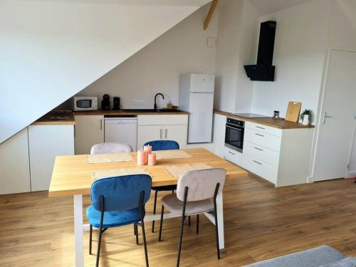 eine Küche mit einem Holztisch und Stühlen in der Unterkunft Appartement avec vue in Fougères