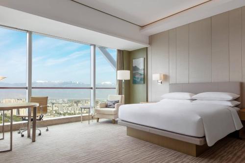 銀川市にあるCourtyard by Marriott Yinchuanのベッドルーム1室(ベッド1台、大きな窓付)