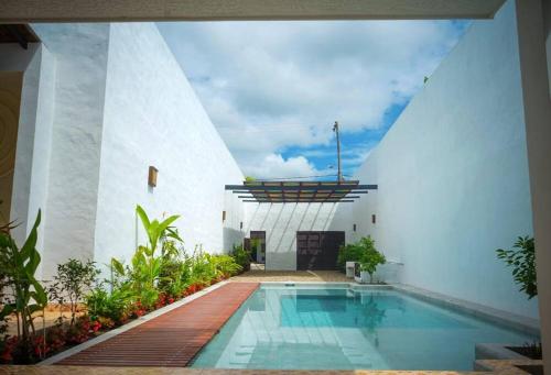 a swimming pool in front of a white building at Casa Amarilla in Honda