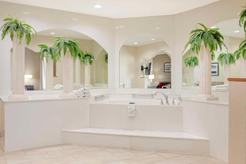ein Badezimmer mit einer Badewanne und zwei Palmen in der Unterkunft Best Western Plus Bradbury Inn and Suites in Waycross