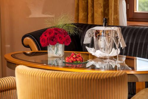 a table with a vase of roses and a plate of fruit at Dorint Am Goethepark Weimar in Weimar