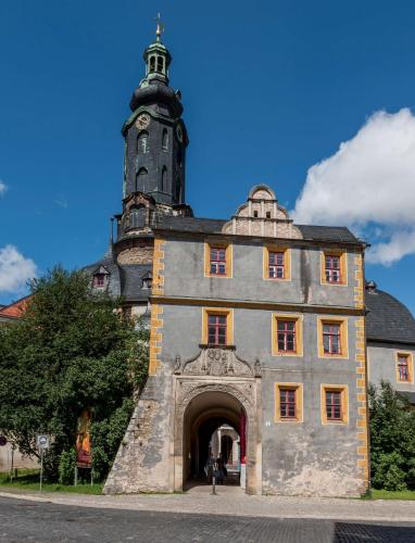 a building with a clock tower on top of it at Dorint Am Goethepark Weimar in Weimar