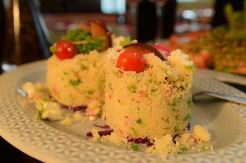 a white plate with a piece of cake with tomatoes on it at Radisson Blu Hotel Guwahati in Guwahati