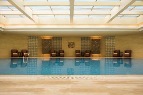 上海的住宿－上海西藏大廈萬怡酒店，大楼内带椅子的大型游泳池