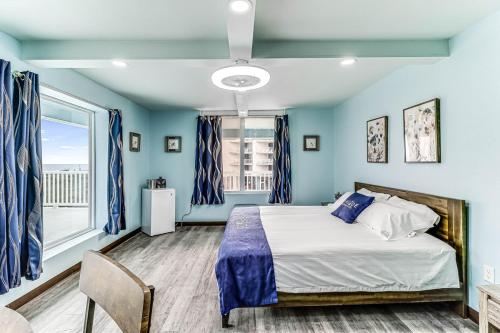 a blue bedroom with a bed and a window at Seaside Boutique Hotel, Waves At Your Doorstep in Port Aransas