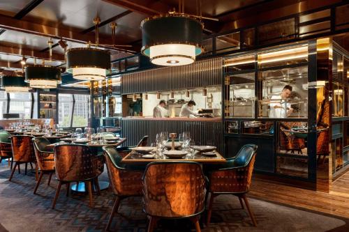 a restaurant with tables and chairs and a kitchen at JW Marriott Marquis Hotel Shanghai Pudong in Shanghai