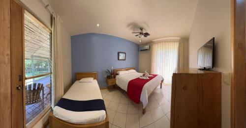 een slaapkamer met 2 bedden en een raam bij Hotel Sol Sámara in Sámara