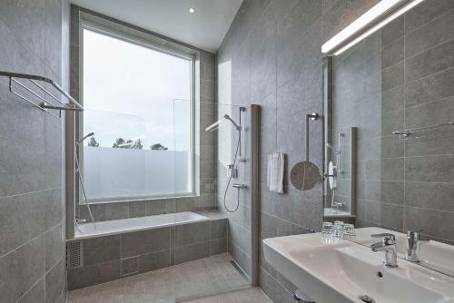 a bathroom with a sink and a tub and a shower at Scandic Kiruna in Kiruna