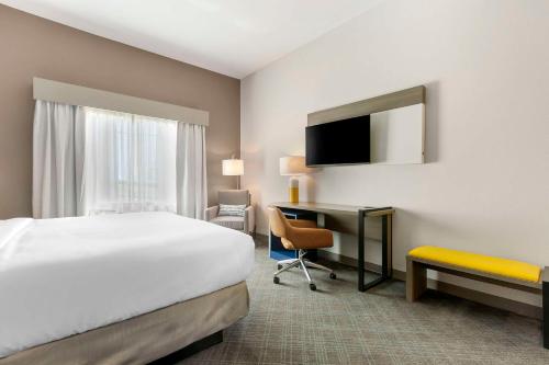 a hotel room with a bed and a desk at Comfort Inn & Suites Houma in Houma