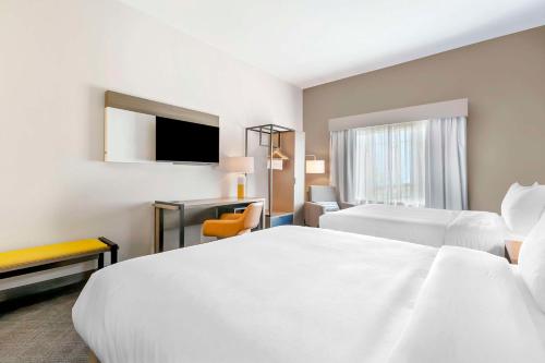 a hotel room with two beds and a television at Comfort Inn & Suites Houma in Houma
