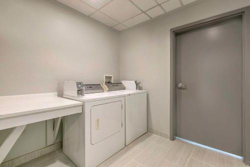 a laundry room with a washer and dryer next to a door at Comfort Inn & Suites Houma in Houma