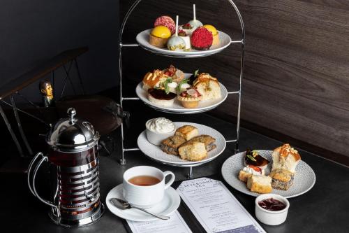 a table with plates of pastries and cups of tea at Fairmont Vancouver Airport In-Terminal Hotel in Richmond