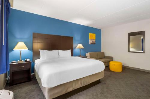 a hotel room with a large bed and a blue wall at Comfort Inn & Suites Mundelein-Vernon Hills in Mundelein