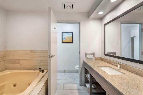 ein Badezimmer mit zwei Waschbecken, einer Badewanne und einem Spiegel in der Unterkunft Comfort Inn & Suites Mundelein-Vernon Hills in Mundelein