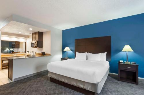 MundeleinにあるComfort Inn & Suites Mundelein-Vernon Hillsの大きなベッドとキッチンが備わるホテルルームです。