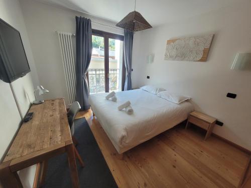 a bedroom with a bed and a table and a window at 4-star apartments in Chamonix centre with free private parking in Chamonix