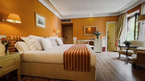 um quarto com uma cama grande e paredes cor-de-laranja em Alhambra Palace Hotel em Granada