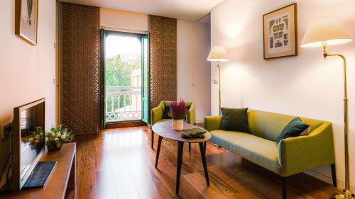 uma sala de estar com um sofá e uma mesa em Alhambra Palace Hotel em Granada