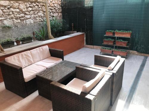een patio met 2 rieten stoelen en een tafel bij Garden Wine Suite in Verona
