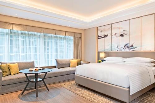 um quarto com uma cama e um sofá em Marriott Executive Apartments Hangzhou Yuhang em Hangzhou