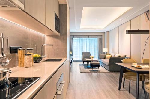 a kitchen and living room with a couch and a table at Marriott Executive Apartments Hangzhou Yuhang in Hangzhou