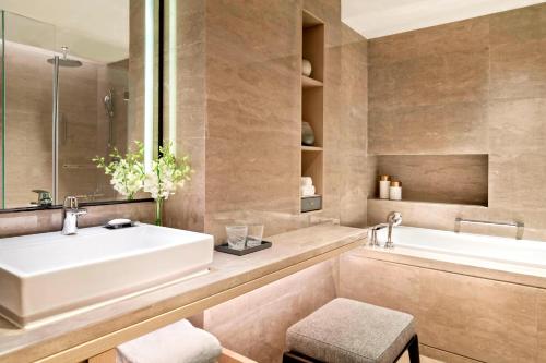 a bathroom with a white sink and a tub at Marriott Executive Apartments Hangzhou Yuhang in Hangzhou