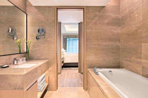 ein Badezimmer mit einer Badewanne und einem Waschbecken in der Unterkunft Marriott Executive Apartments Hangzhou Yuhang in Hangzhou