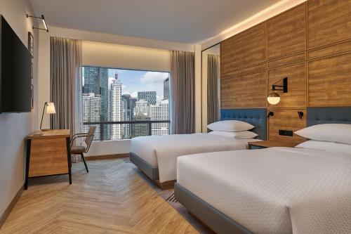 a hotel room with two beds and a large window at Four Points by Sheraton Kuala Lumpur, City Centre in Kuala Lumpur