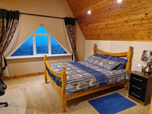 a bedroom with a bed and a large window at Mountain view kingscourt 